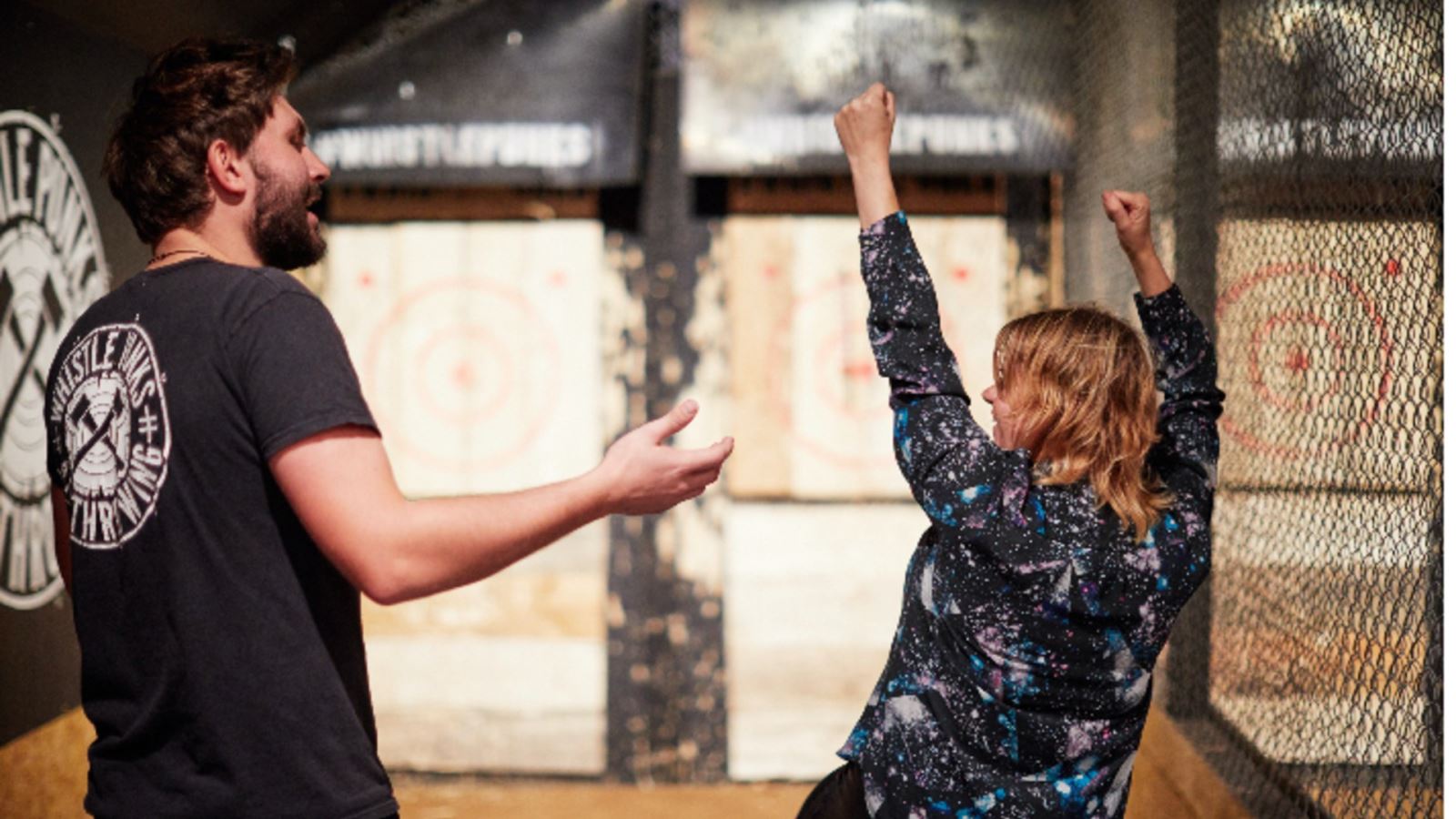 Person with instructor celebrating at Whistle Punks axe throwing